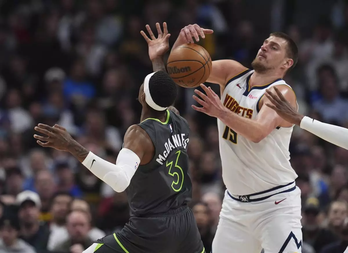 Denver Nuggets center Nikola Jokic, right, steals the ball from Minnesota Timberwolves forward Jaden McDaniels in the first half of an NBA basketball game Tuesday, April 1, 2025, in Denver. (AP Photo/David Zalubowski)