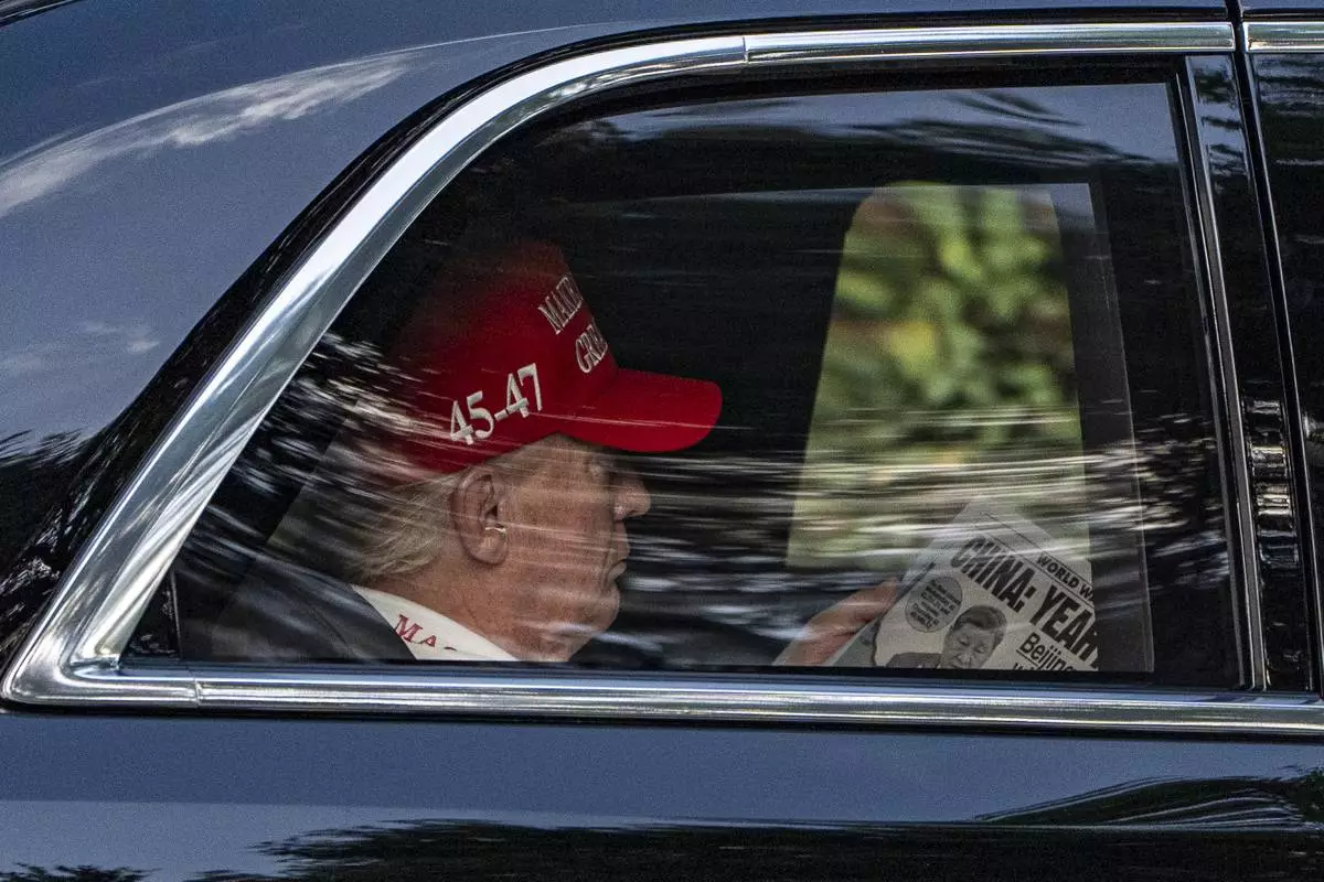 President Donald Trump reads The NY Post as he arrives at the Trump National Golf Club, April 5, 2025, in Jupiter, Fla. (AP Photo/Alex Brandon)