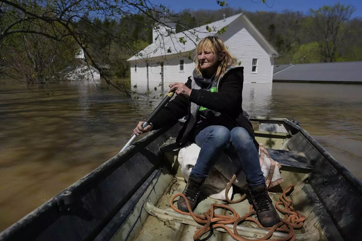 Wanona Harp paddles past inundated churches in Lockport, Ky., flooded by the Kentucky River, April 8, 2025. (AP Photo/Carolyn Kaster)