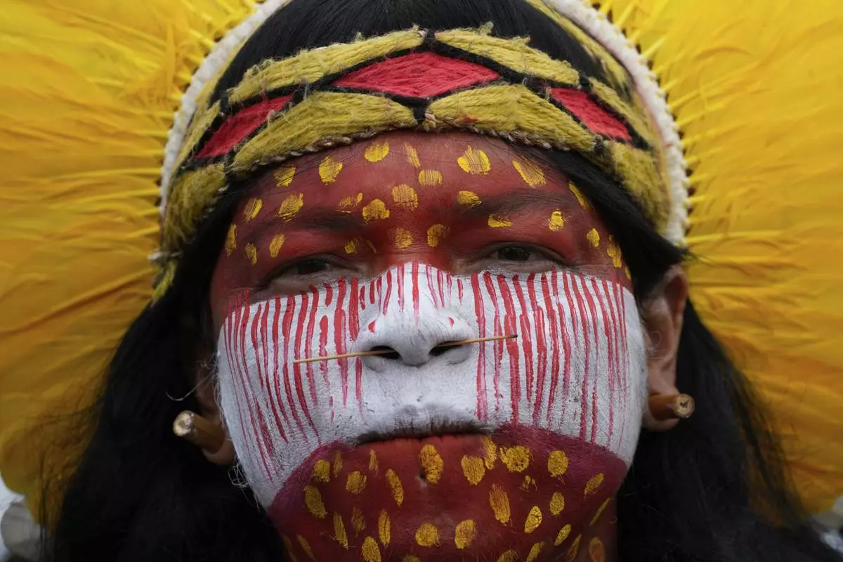 An Indigenous woman attends in the annual Free Earth camp where Brazil's Indigenous communities discuss rights, territorial protection and their role in COP30 which will take place for the first time in the Amazon, in Brasilia, Brazil, April 8, 2025. (AP Photo/Eraldo Peres)