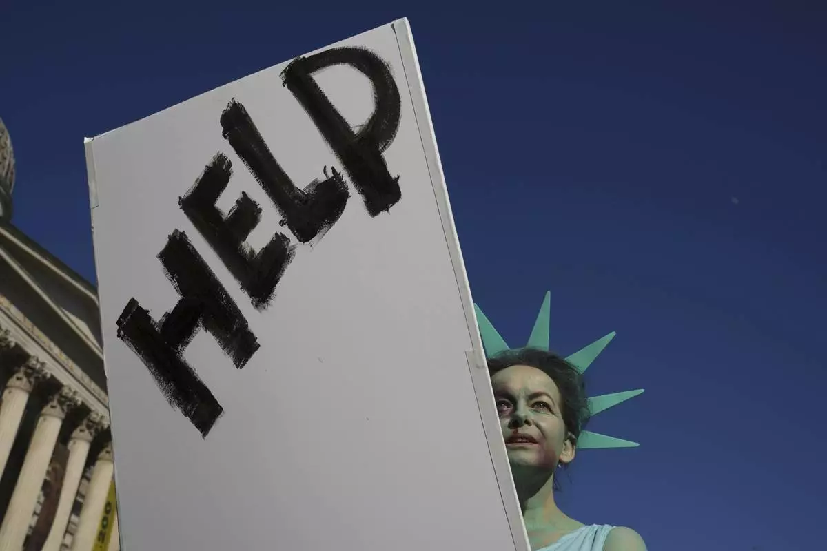 Helena Jensen joins a "Hands Off!" demonstration against President Donald Trump and Elon Musk, at Trafalgar Square in London, April 5, 2025. (AP Photo/Kin Cheung)