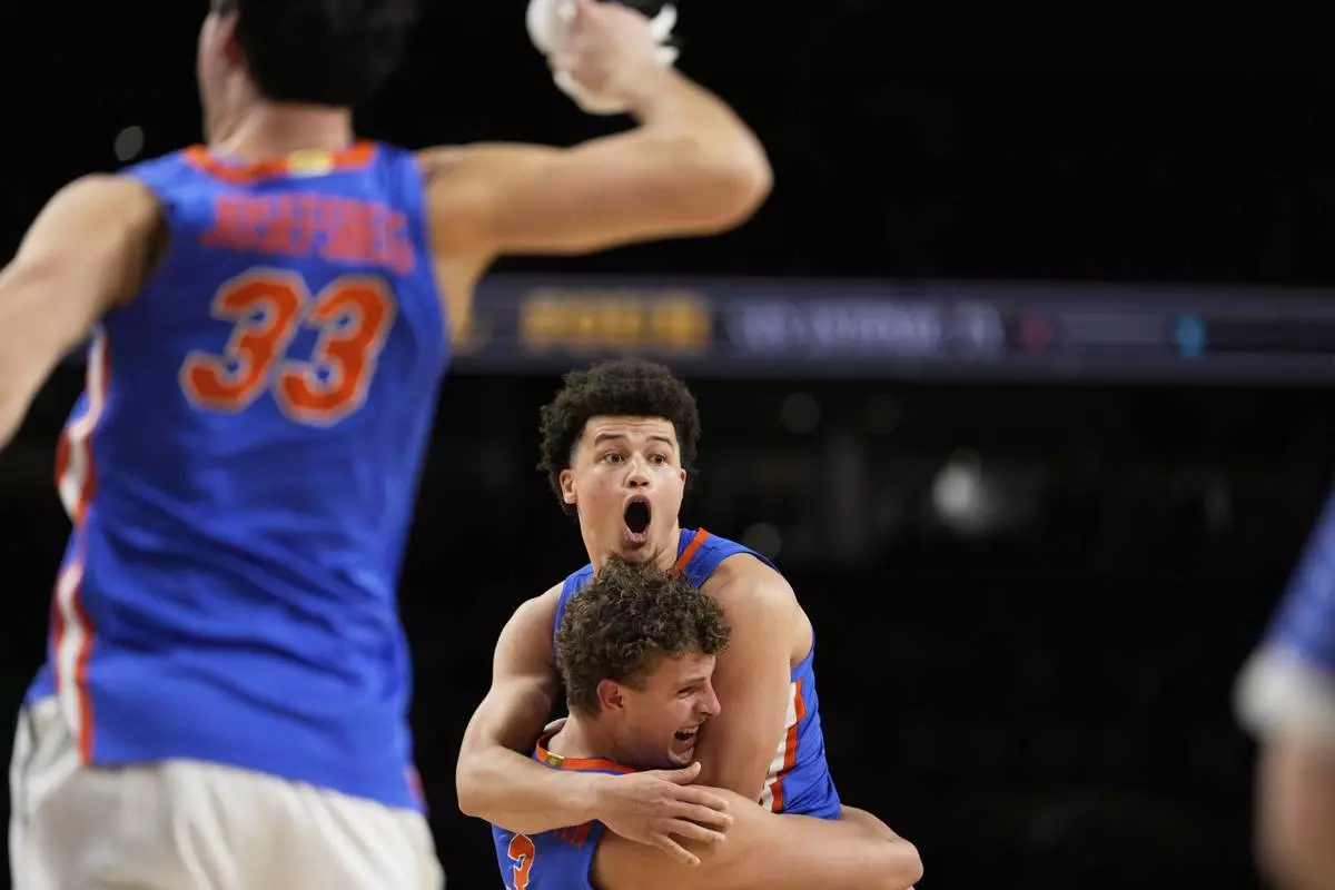 Florida guard Walter Clayton Jr. and center Micah Handlogten celebrate their win against Houston in the NCAA mens' title-game in San Antonio, April 7, 2025. (AP Photo/Brynn Anderson)