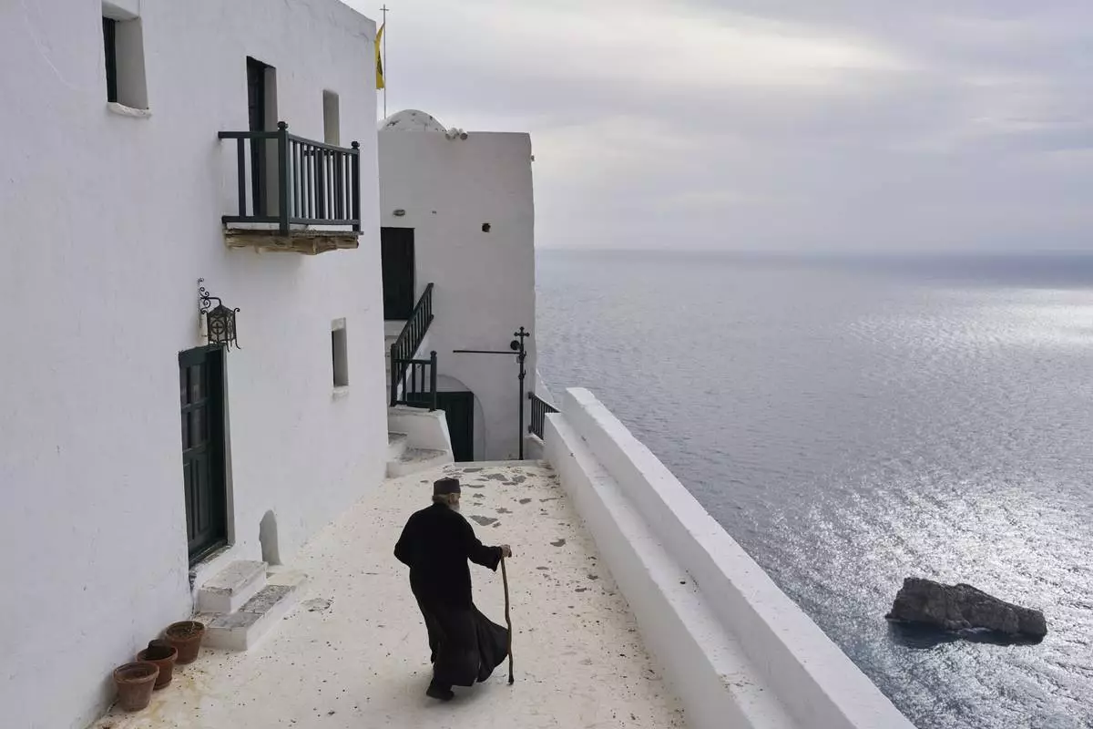 Orthodox Christian monk Father Spyridon walks at the Monastery of Panagia Hozoviotissa along the Aegean Sea, on the island of Amorgos, Greece, March 27, 2025. (AP Photo/Petros Giannakouris)
