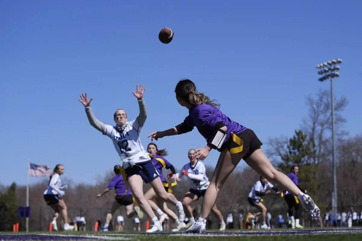 University of Northwestern St. Paul and University of Wisconsin - Stout players compete during a women's college flag football game, April 7, 2025, in St. Paul. Minn. (AP Photo/Abbie Parr)
