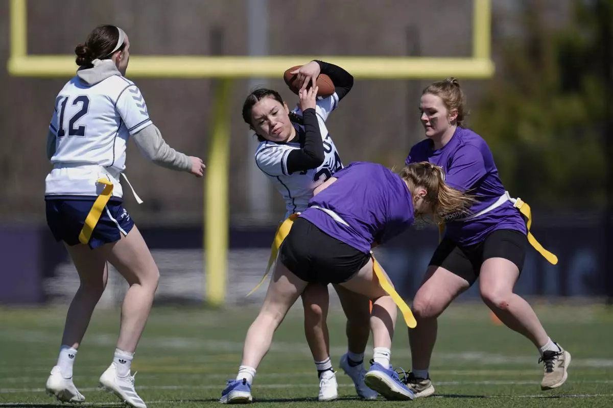 University of Northwestern St. Paul and University of Wisconsin - Stout players compete during a women's college flag football game, April 7, 2025, in St. Paul. Minn. (AP Photo/Abbie Parr)
