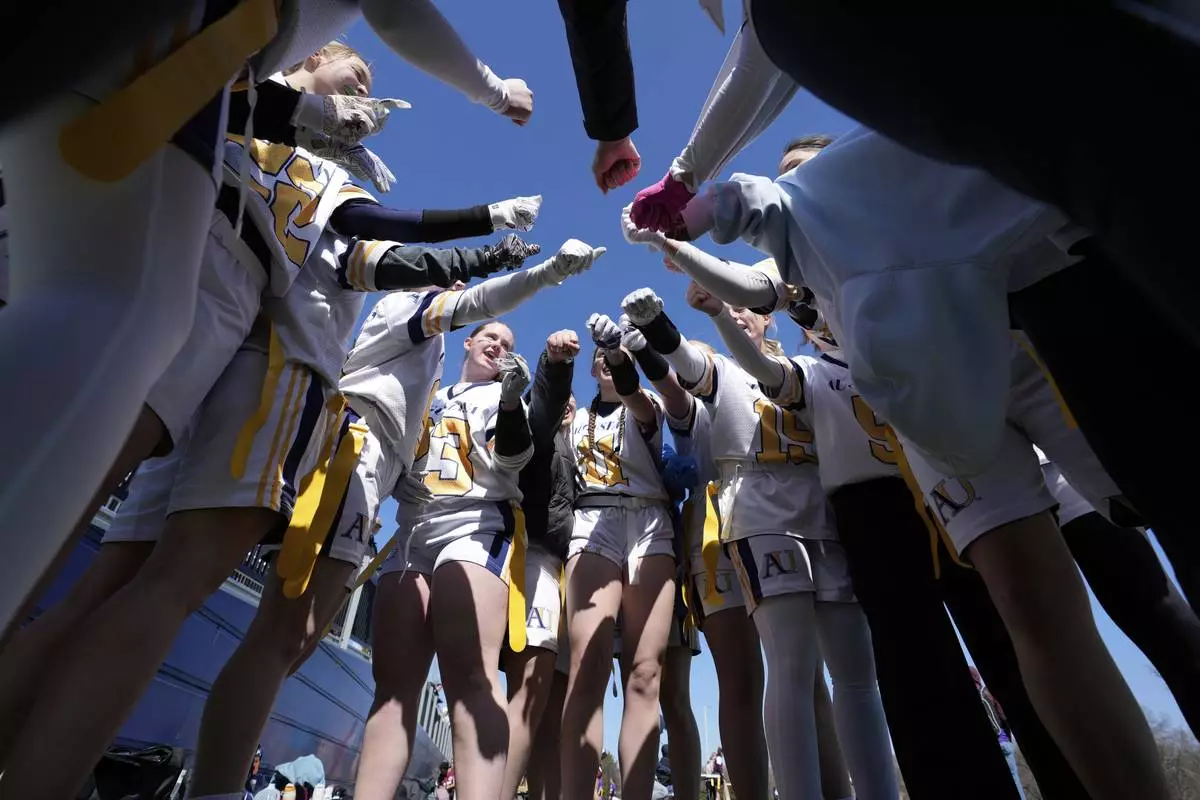 Augustana University players huddle before a women's college flag football game against Concordia University, St. Paul, April 7, 2025, in St. Paul. Minn. (AP Photo/Abbie Parr)