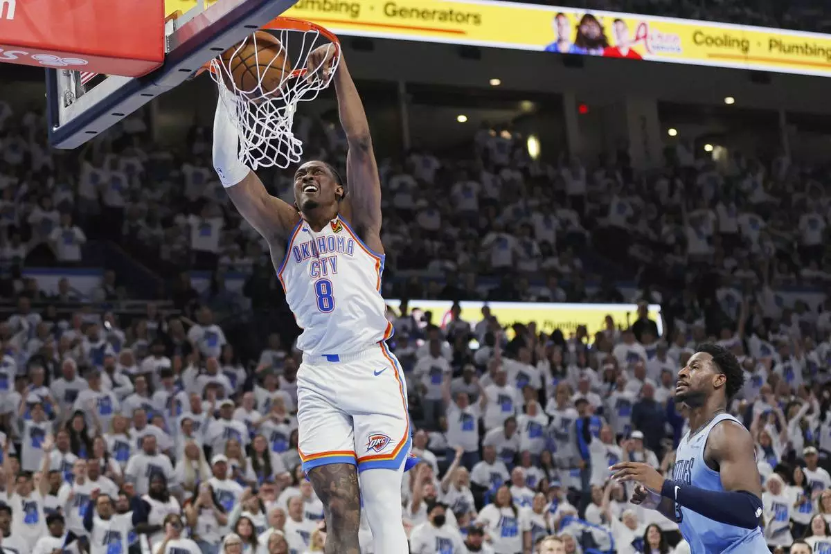 Oklahoma City Thunder forward Jalen Williams (8) dunks as Memphis Grizzlies forward Jaren Jackson Jr., right, looks on during the first half in Game 1 of an NBA first-round playoff series, Sunday, April 20, 2025, in Oklahoma City. (AP Photo/Nate Billings)