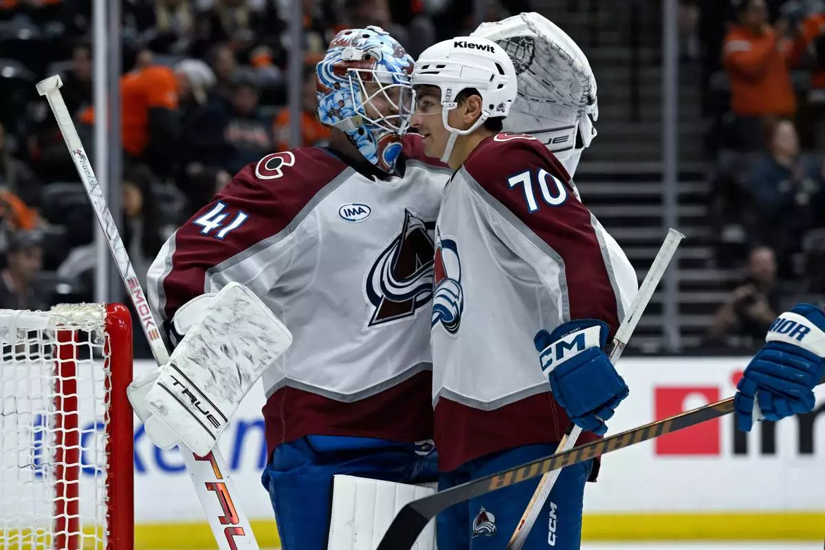 Colorado Avalanche defenseman Sam Malinski (70) celebrates with goaltender Scott Wedgewood (41) after the Avalanche defeated the Anaheim Ducks in an NHL hockey game in Anaheim, Calif., Sunday, April 13, 2025. (AP Photo/Alex Gallardo)