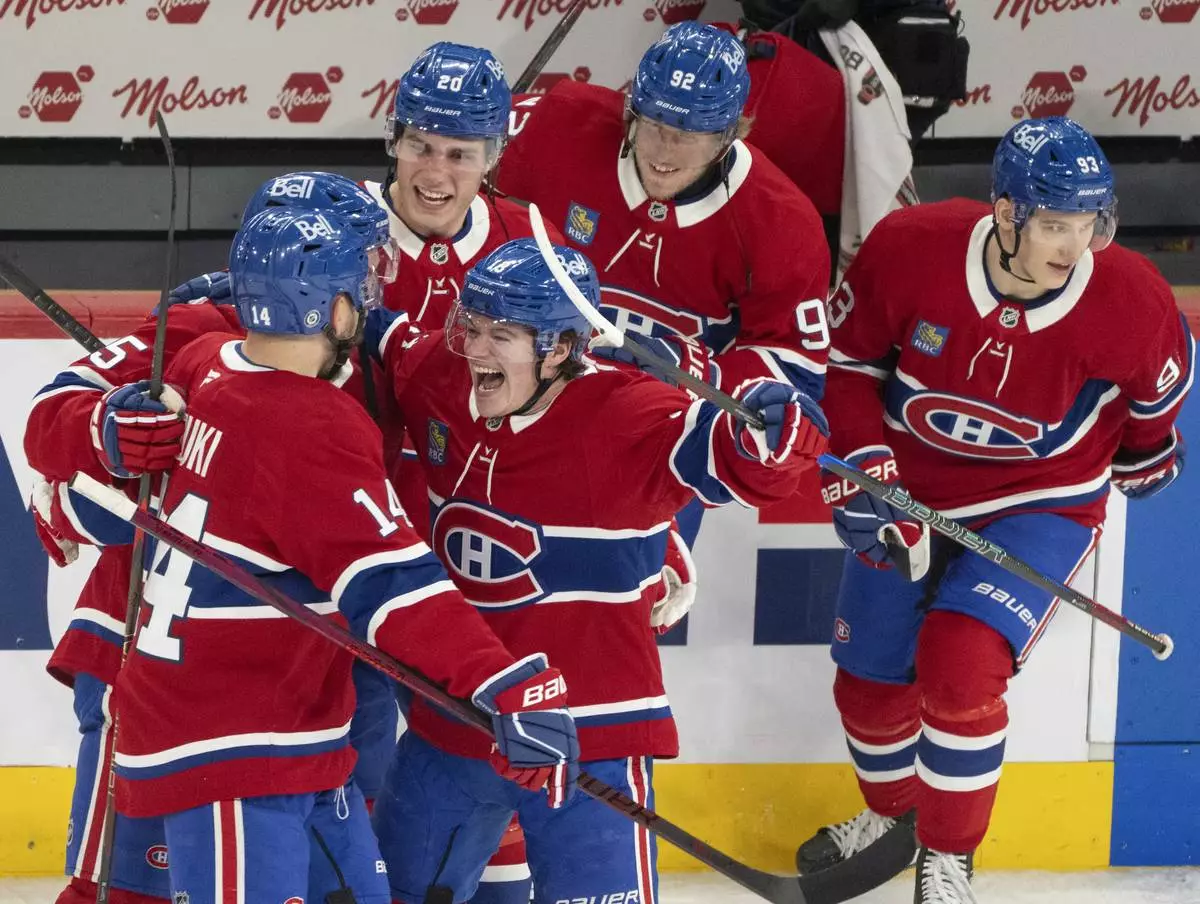 Montreal Canadiens' Cole Caufield, centre, celebrates with teammates after their win against the Carolina Hurricanes during third period NHL hockey action in Montreal on Wednesday, April 16, 2025. (Christinne Muschi/The Canadian Press via AP)