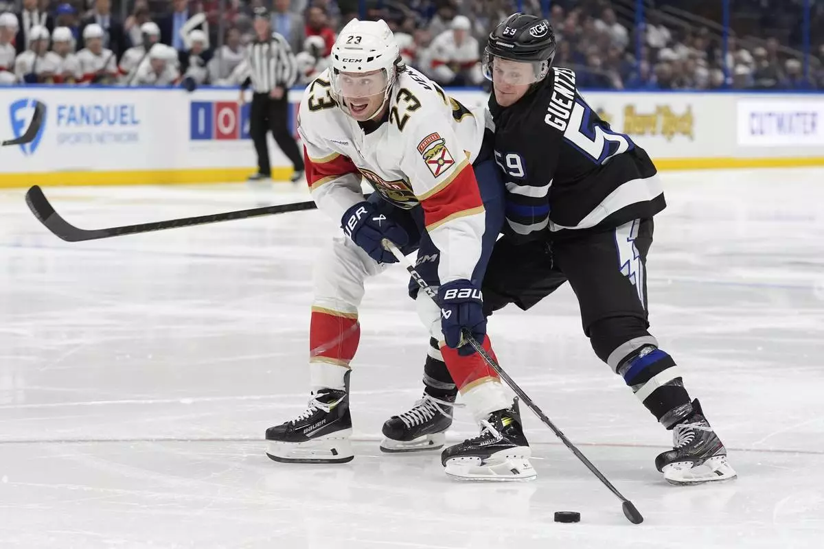 Florida Panthers center Carter Verhaeghe (23) gets around Tampa Bay Lightning center Jake Guentzel (59) during the third period of an NHL hockey game Tuesday, April 15, 2025, in Tampa, Fla. (AP Photo/Chris O'Meara)
