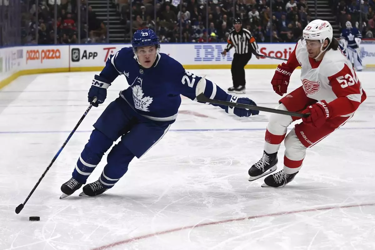 Toronto Maple Leafs' Pontus Holmberg (29) moves the puck around Detroit Red Wings' Moritz Seider (53) during the second period of an NHL hockey game Thursday, April 17, 2025, in Toronto. (Jon Blacker/The Canadian Press via AP)