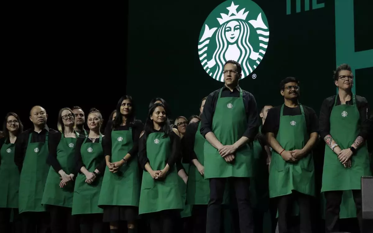 FILE - Starbucks baristas stand on stage, March 20, 2019, during an annual shareholders meeting in Seattle. (AP Photo/Ted S. Warren, file)