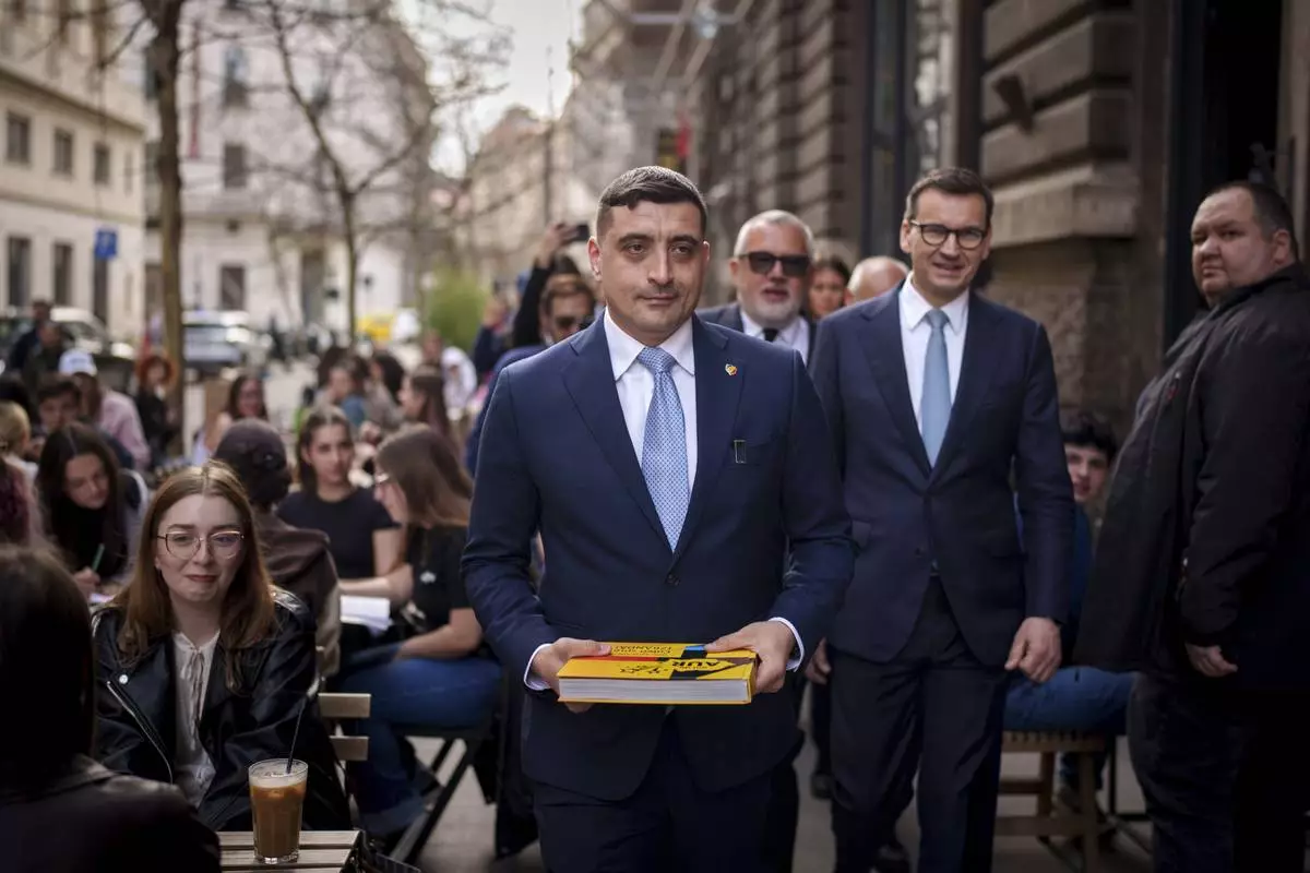 FILE - George Simion, the leader of Romania's most popular far-right party, the Alliance for the Union of Romanians (AUR), walks with former Polish Prime Minister Mateusz Morawiecki, right, in Bucharest, Romania, Friday, March 14, 2025, after filing his candidacy to participate in the country's presidential election rerun in May. (AP Photo/Vadim Ghirda, File)