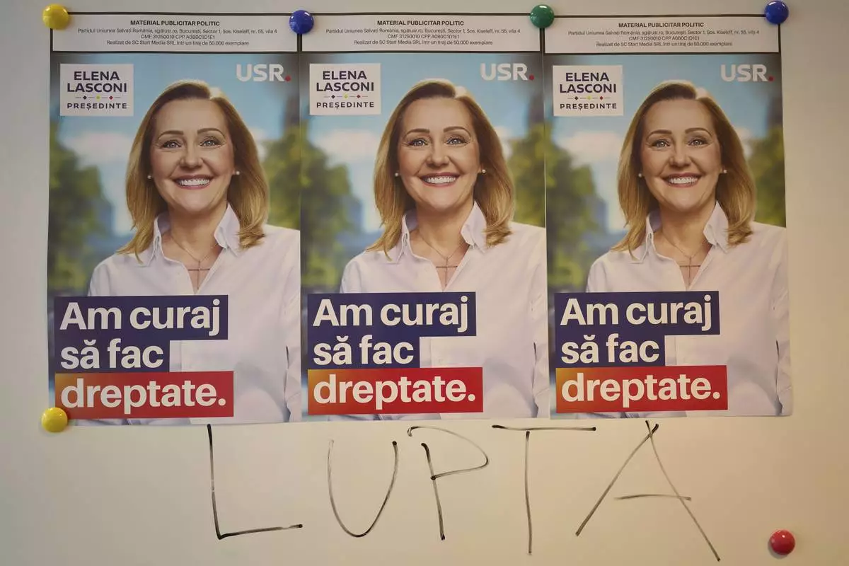 The word "Fight" is written on a board below posters of Elena Lasconi, presidential candidate for the Save Romania Union party, or USR, before it withdrew its support for her last week in favor of incumbent Bucharest mayor Nicusor Dan, at a party headquarter in Bucharest, Romania, Tuesday, April 15, 2025. (AP Photo/Vadim Ghirda)