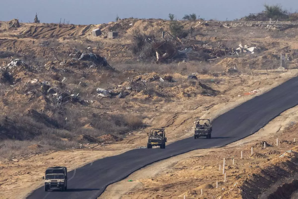 FILE - Israeli military vehicles move inside the Gaza Strip, as seen from southern Israel, Tuesday, Jan. 7, 2025. (AP Photo/Ariel Schalit, File)