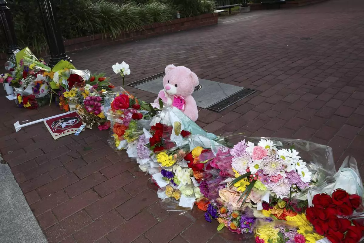 An impromptu memorial of flowers and other items laid near the center of the Florida State campus in sight of the Student Union building, Tallahassee, Fla., Thursday, April 17, 2025. (AP Photo/Gary McCullough)