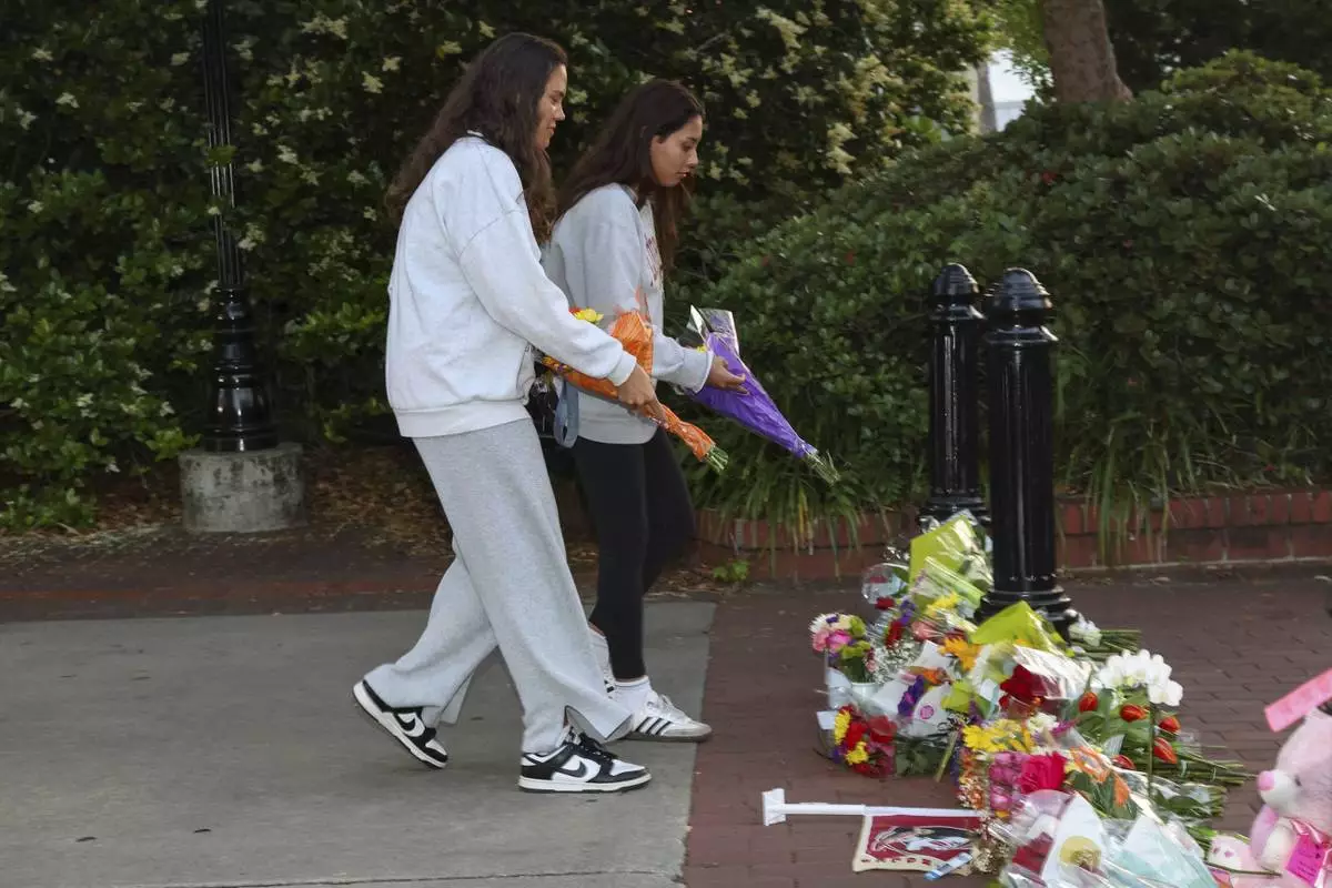 An impromptu memorial shared online brings students bearing flowers near the center of the Florida State campus in sight of the Student Union building, Tallahassee, Fla., Thursday, April 17, 2025. (AP Photo/Gary McCullough)