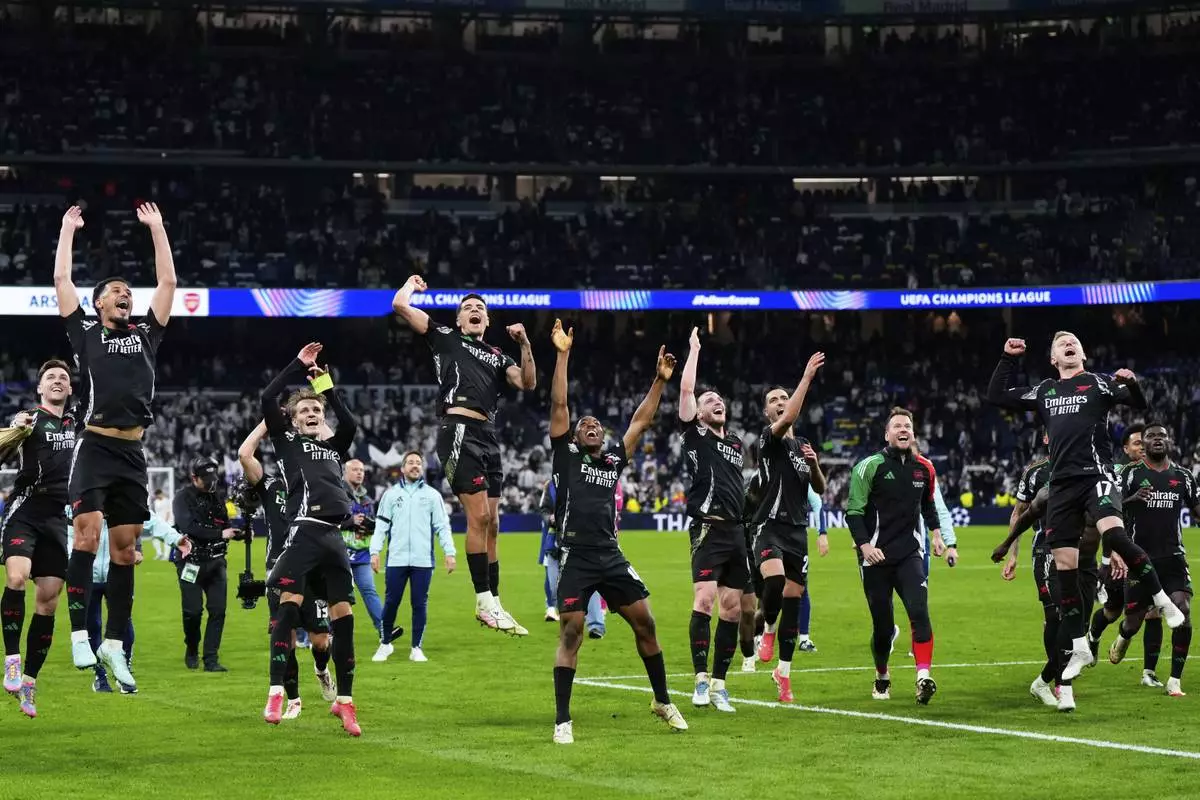 Arsenal players celebrate after defeating Real Madrid 2-1 in the Champions League quarterfinals second leg soccer match at the Santiago Bernabeu stadium in Madrid, Wednesday, April 16, 2025. (AP Photo/Manu Fernandez)