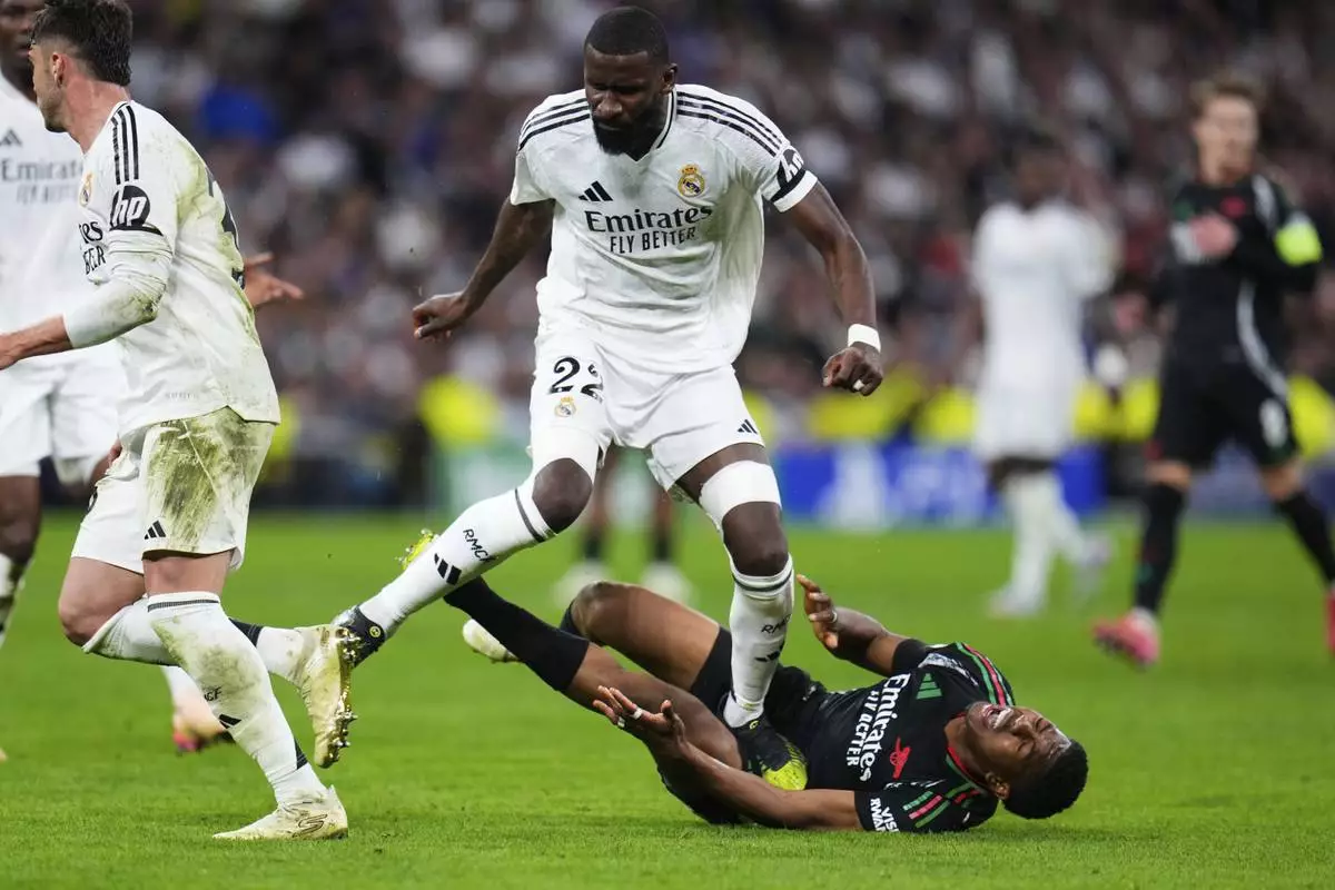 Real Madrid's Antonio Ruediger steps on Arsenal's Myles Lewis-Skelly, on the ground, during the Champions League quarterfinals second leg soccer match between Real Madrid and Arsenal at the Santiago Bernabeu stadium in Madrid, Wednesday, April 16, 2025. (AP Photo/Manu Fernandez)
