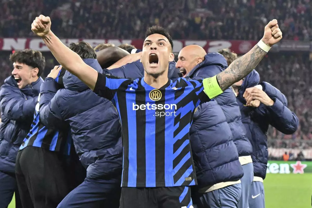 Inter's Lautaro Martinez, center, and Nicolo Barella, right, celebrate after the Champions League quarterfinals first leg soccer match between FC Bayern Munich and Inter Milan, at the Allianz Arena in Munich, Germany, Tuesday, April 8, 2025. (Peter Kneffel/dpa via AP)