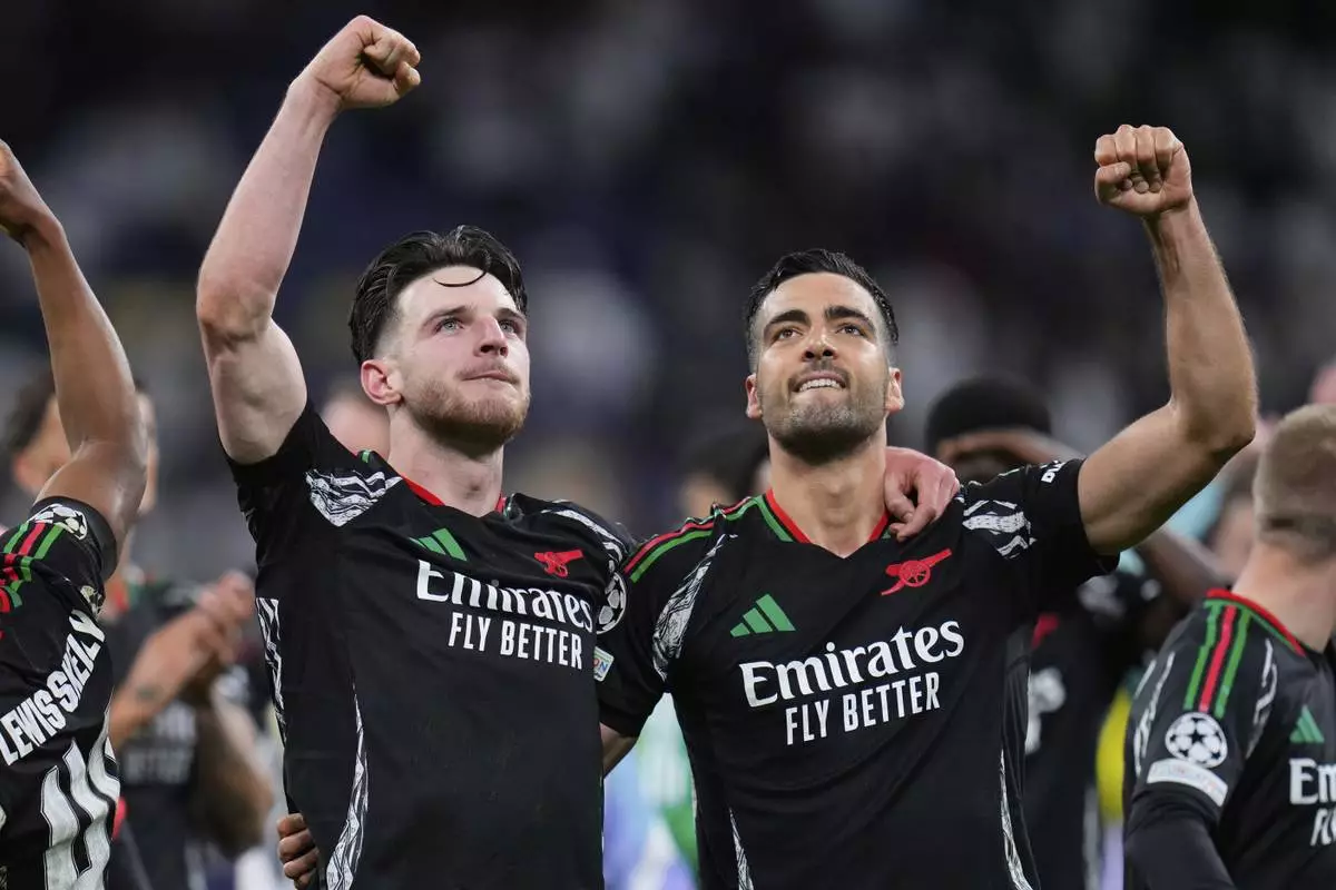 Arsenal's Declan Rice and Mikel Merino, right, celebrate after defeating Real Madrid 2-1 in the Champions League quarterfinals second leg soccer match at the Santiago Bernabeu stadium in Madrid, Wednesday, April 16, 2025. (AP Photo/Manu Fernandez)