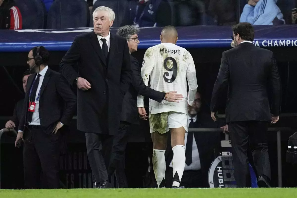 Real Madrid's Kylian Mbappe, center, leaves the field after sustaining an injury during the Champions League quarterfinals second leg soccer match between Real Madrid and Arsenal at the Santiago Bernabeu stadium in Madrid, Wednesday, April 16, 2025. (AP Photo/Bernat Armangue)