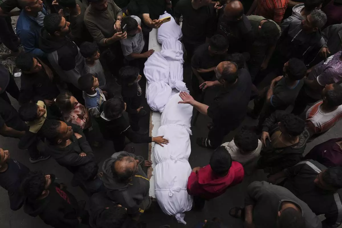 Relatives grieve over the bodies of members of the Jalis and Al-Sharbasi families, killed in an Israeli army airstrike on Yaffa School in Gaza City, Wednesday, April 23, 2025. (AP Photo/Jehad Alshrafi)