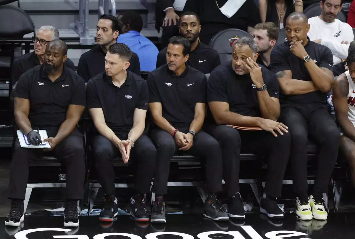 Miami Heat head coach Erik Spoelstra, center, and the Heat coaching staff sit in the bench during the second half in Game 4 of an NBA basketball first-round playoff series against the Cleveland Cavaliers, Monday, April 28, 2025, in Miami. (AP Photo/Rhona Wise)