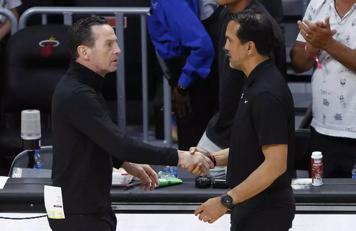 Cleveland Cavaliers head coach Kenny Atkinson, left, and Miami Heat head coach Erik Spoelstra, right, shake hands following Game 4 of an NBA basketball first-round playoff series, Monday, April 28, 2025, in Miami. (AP Photo/Rhona Wise)