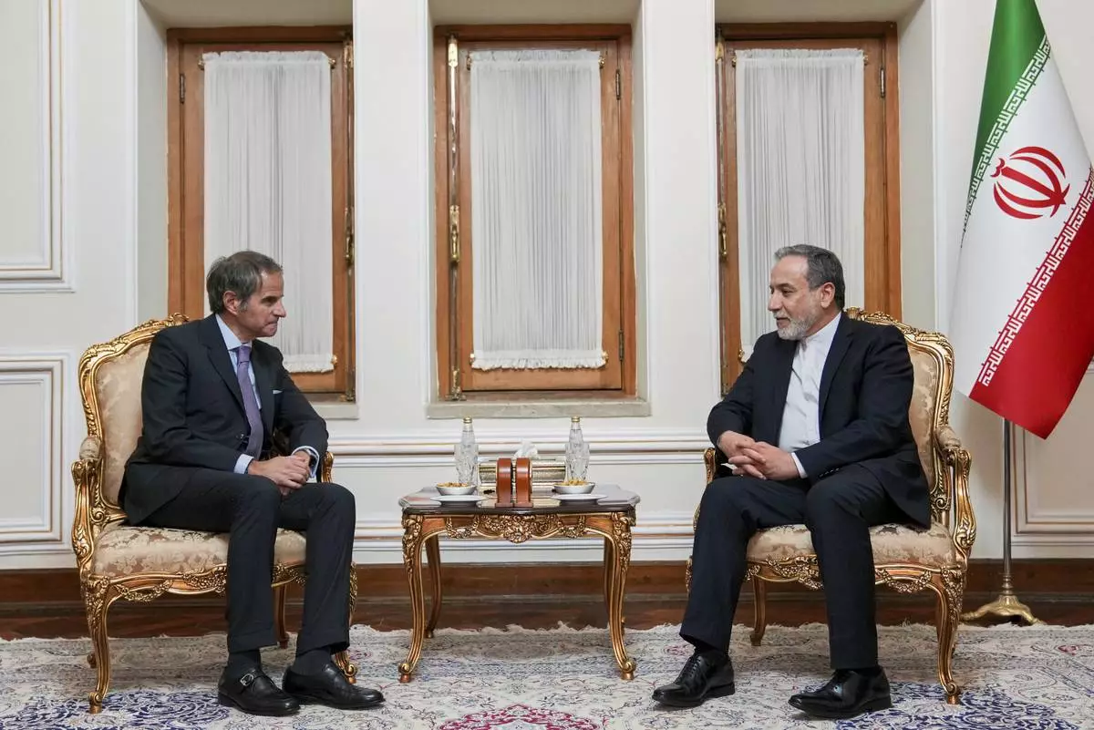 In this photo released by the Iranian Foreign Ministry, Foreign Minister Abbas Araghchi, right, speaks with International Atomic Energy Agency (IAEA) Director General Rafael Mariano Grossi during their meeting in Tehran, Iran, Wednesday, April 16, 2025. (Iranian Foreign Ministry via AP)