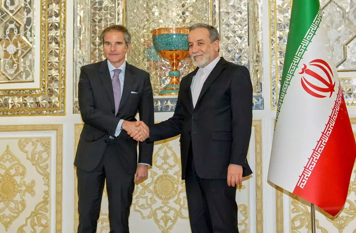 In this photo released by the Iranian Foreign Ministry, Foreign Minister Abbas Araghchi, right, shakes hands with the International Atomic Energy Agency (IAEA) Director General Rafael Mariano Grossi prior to their meeting in Tehran, Iran, Wednesday, April 16, 2025. (Iranian Foreign Ministry via AP)