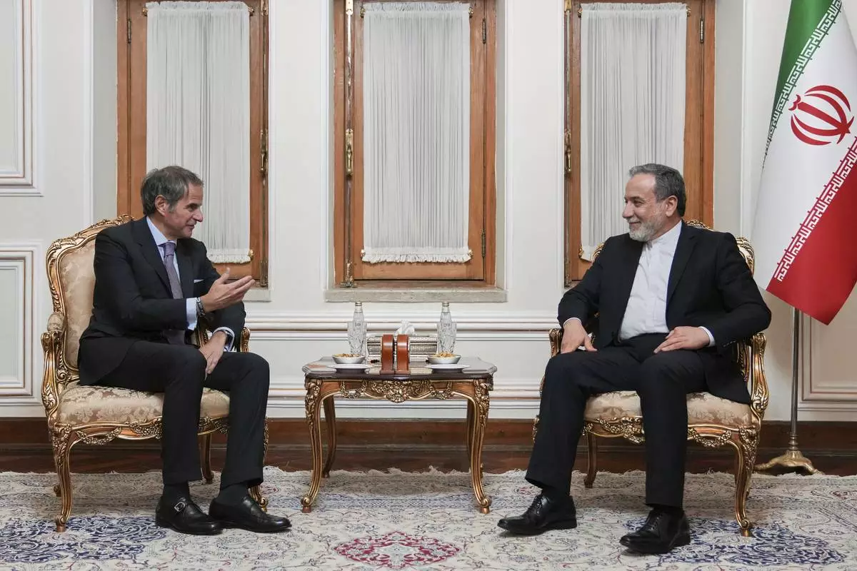 In this photo released by the Iranian Foreign Ministry, Foreign Minister Abbas Araghchi, right, listens to International Atomic Energy Agency (IAEA) Director General Rafael Mariano Grossi during their meeting in Tehran, Iran, Wednesday, April 16, 2025. (Iranian Foreign Ministry via AP)