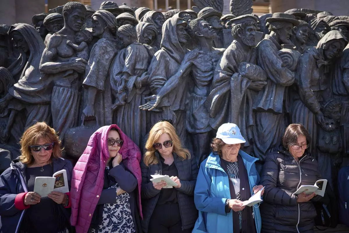 Faithful listen to mass during the funeral of Pope Francis in St. Peter's Square at the Vatican, Saturday, April 26, 2025. (AP Photo/Emilio Morenatti)