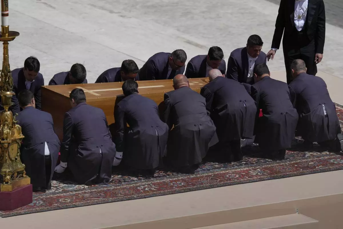 Pallbearers bend to lift the coffin of Pope Francis at the end of his funeral in St. Peter's Square at the Vatican, Saturday, April 26, 2025. (AP Photo/Gregorio Borgia)