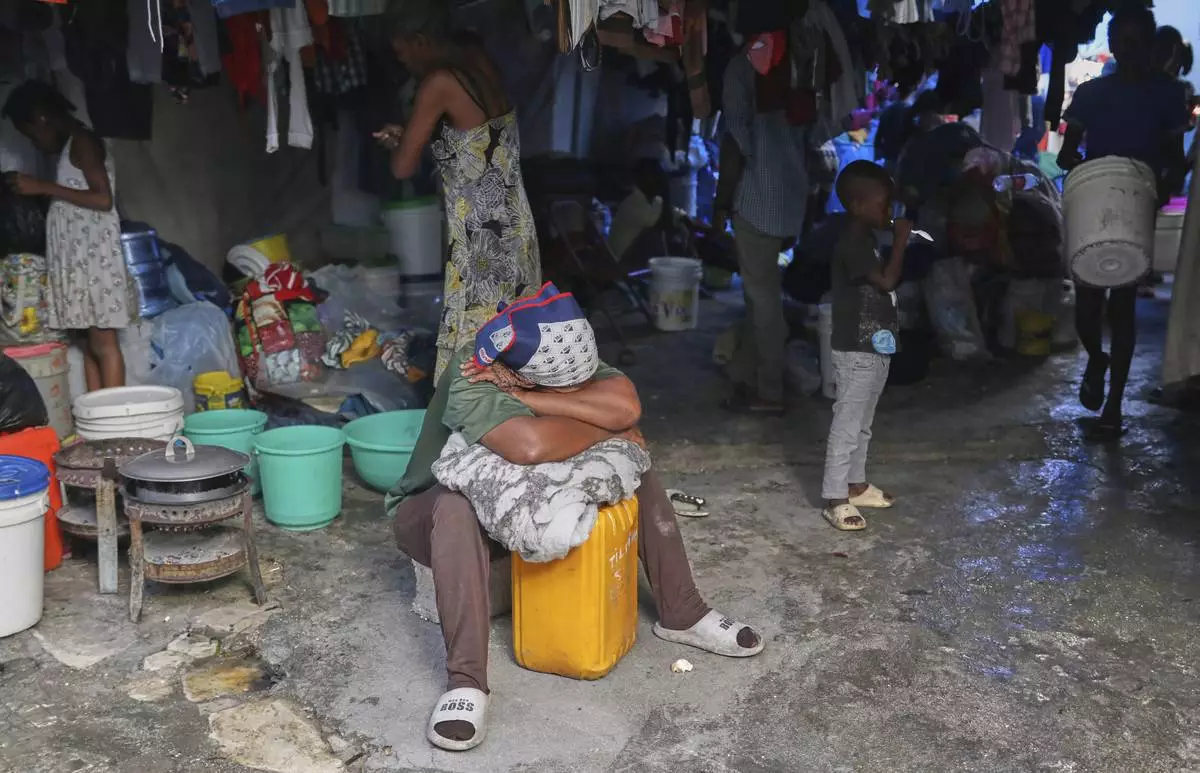 A displaced woman rests at a school that is now operating as a shelter for those fleeing their homes to escape gang violence in Port-au-Prince, Haiti, Monday, April 14, 2025. (AP Photo/Odelyn Joseph)
