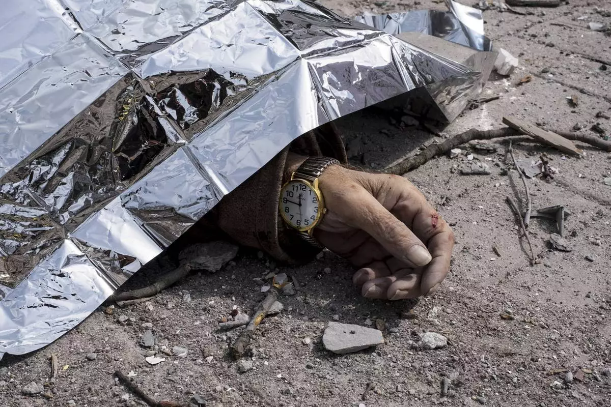 A dead body lies on the ground after a Russian missile strike on Sumy, Ukraine, Sunday April 13, 2025. (AP Photo/Volodymyr Hordiienko)