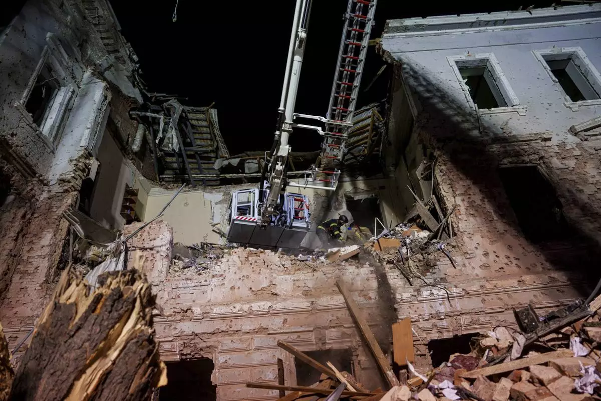 Rescue workers clear the rubble of a university building destroyed by a Russian missile strike on Sumy, Ukraine, Sunday, April 13, 2025. (AP Photo/Evgeniy Maloletka)