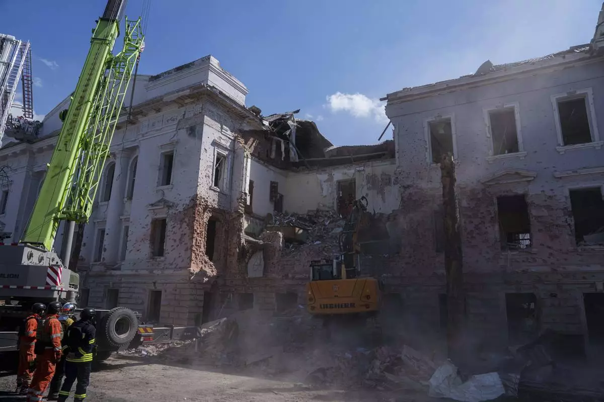 An excavator clears the rubble from a University building destroyed by a Russian missile strike in Sumy, Ukraine, Monday, April 14, 2025. (AP Photo/Evgeniy Maloletka)