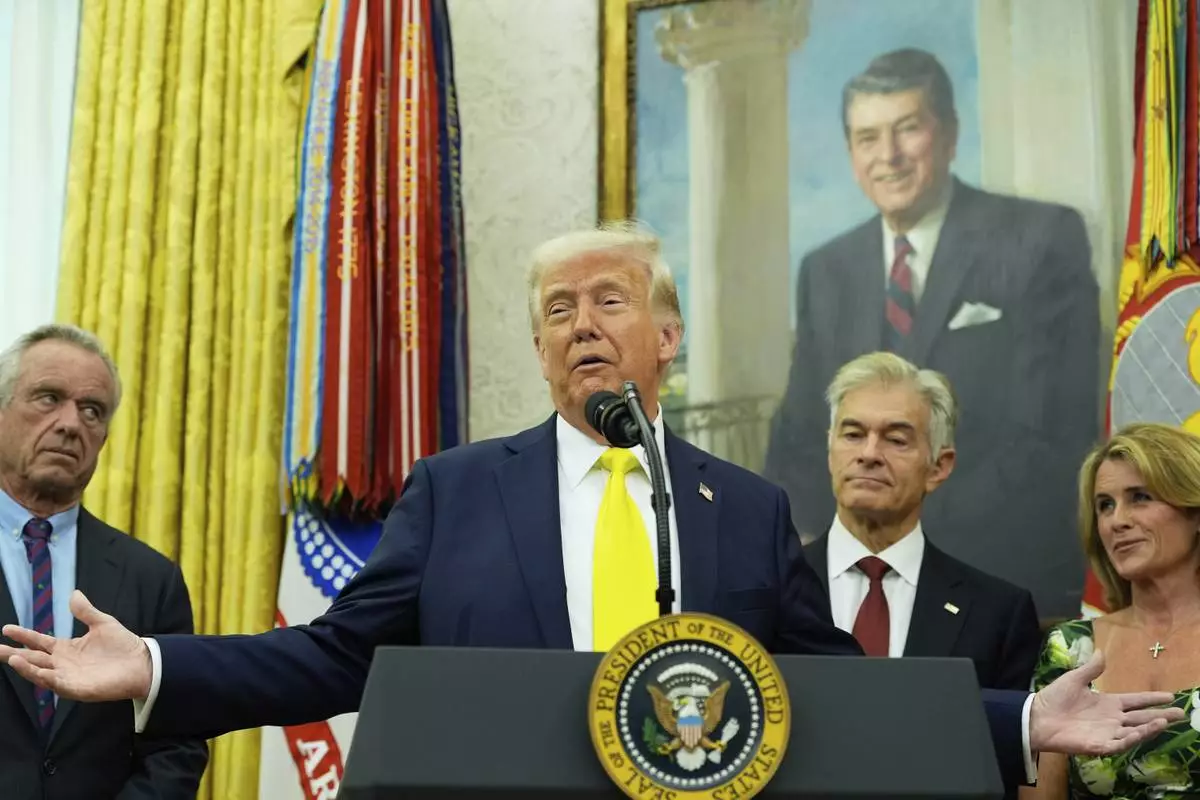 President Donald Trump speaks as Health and Human Services Secretary Robert F. Kennedy Jr., from left, Dr. Mehmet Oz and Oz's wife Lisa Oz listen during a swearing in ceremony for Mehmet oz to be Administrator of the Centers for Medicare and Medicaid Services, in the Oval Office of the White House, Friday, April 18, 2025, in Washington. (AP Photo/Alex Brandon)