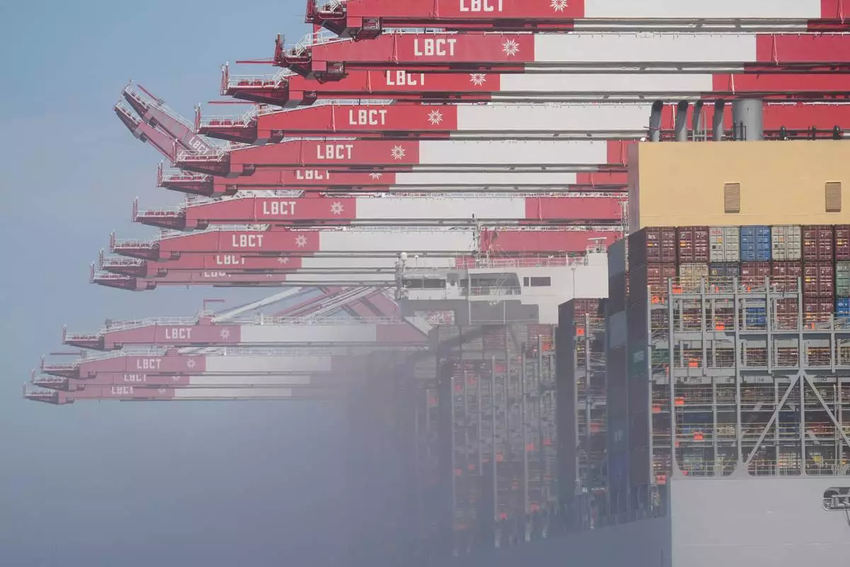 The "OOCL Bauhinia" container ship is covered by fog as it moors at the Long Beach Container Terminal at Middle Harbor in the Port of Long Beach, Calif., Tuesday, April 8, 2025. (AP Photo/Damian Dovarganes)