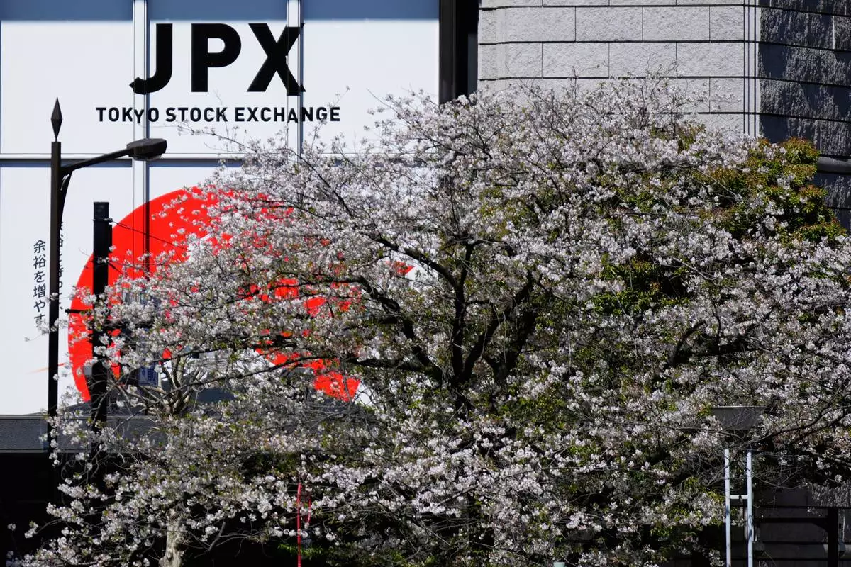 Cherry blossoms bloom across a street from the Tokyo Stock Exchange building in Tokyo, Wednesday, April 9, 2025. (AP Photo/Hiro Komae)