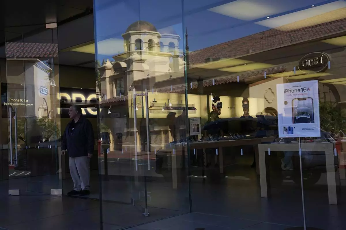 People shop in an Apple store Tuesday, April 8, 2025, in Las Vegas. (AP Photo/John Locher)