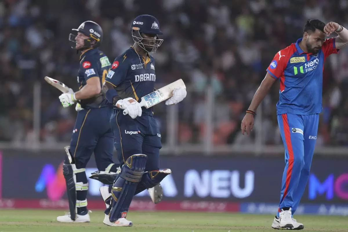 Gujarat Titans' Jos Butler and Sherfane Rutherford run between the wickets to score during the Indian Premier League cricket match between Gujarat Titans and Delhi Capitals at Narendra Modi Stadium in Ahmedabad, India, Saturday, April 19, 2025. (AP Photo/Ajit Solanki)