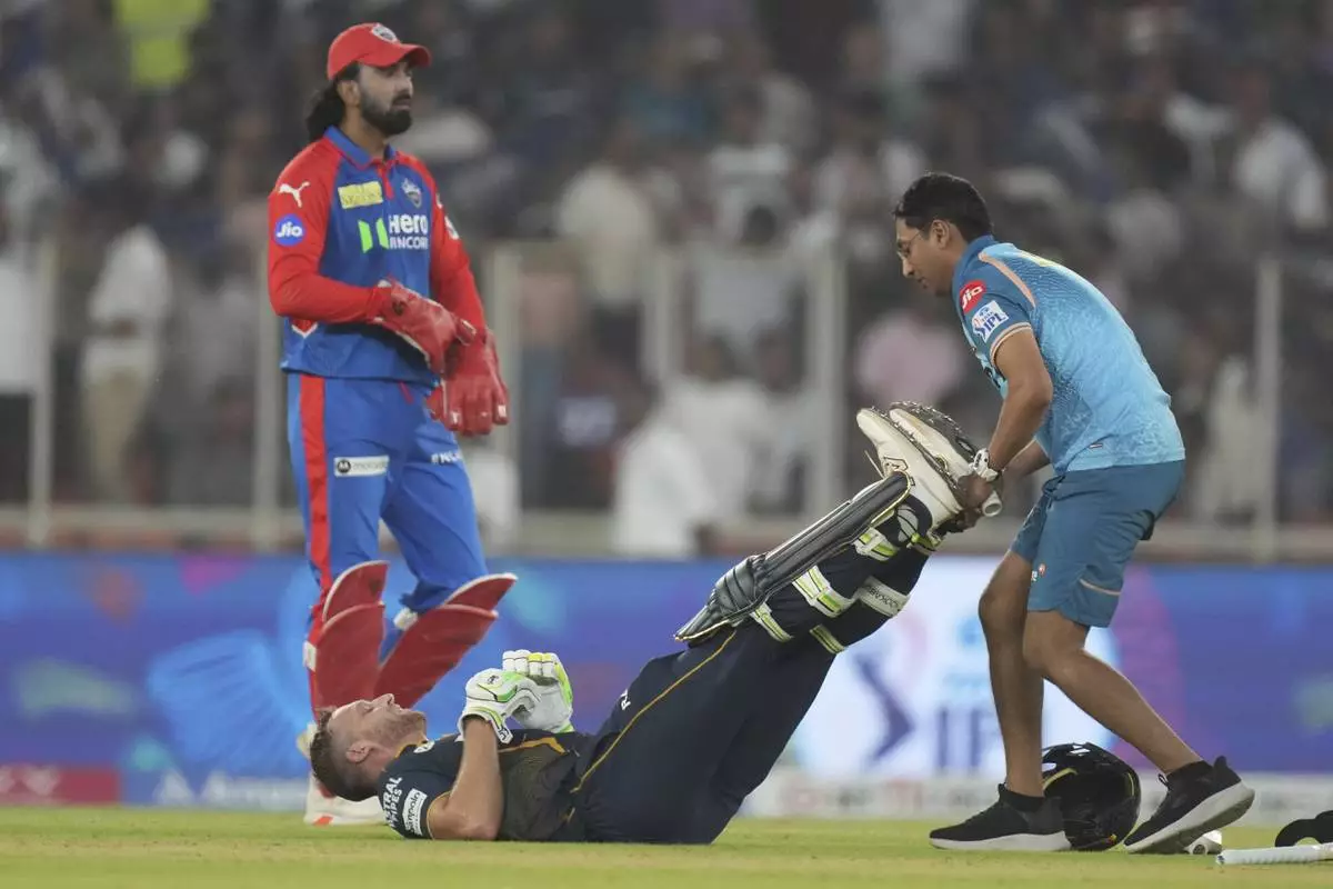 Gujarat Titans' Jos Butler gets medical attention after a muscle pain during the Indian Premier League cricket match between Gujarat Titans and Delhi Capitals at Narendra Modi Stadium in Ahmedabad, India, Saturday, April 19, 2025. (AP Photo/Ajit Solanki)