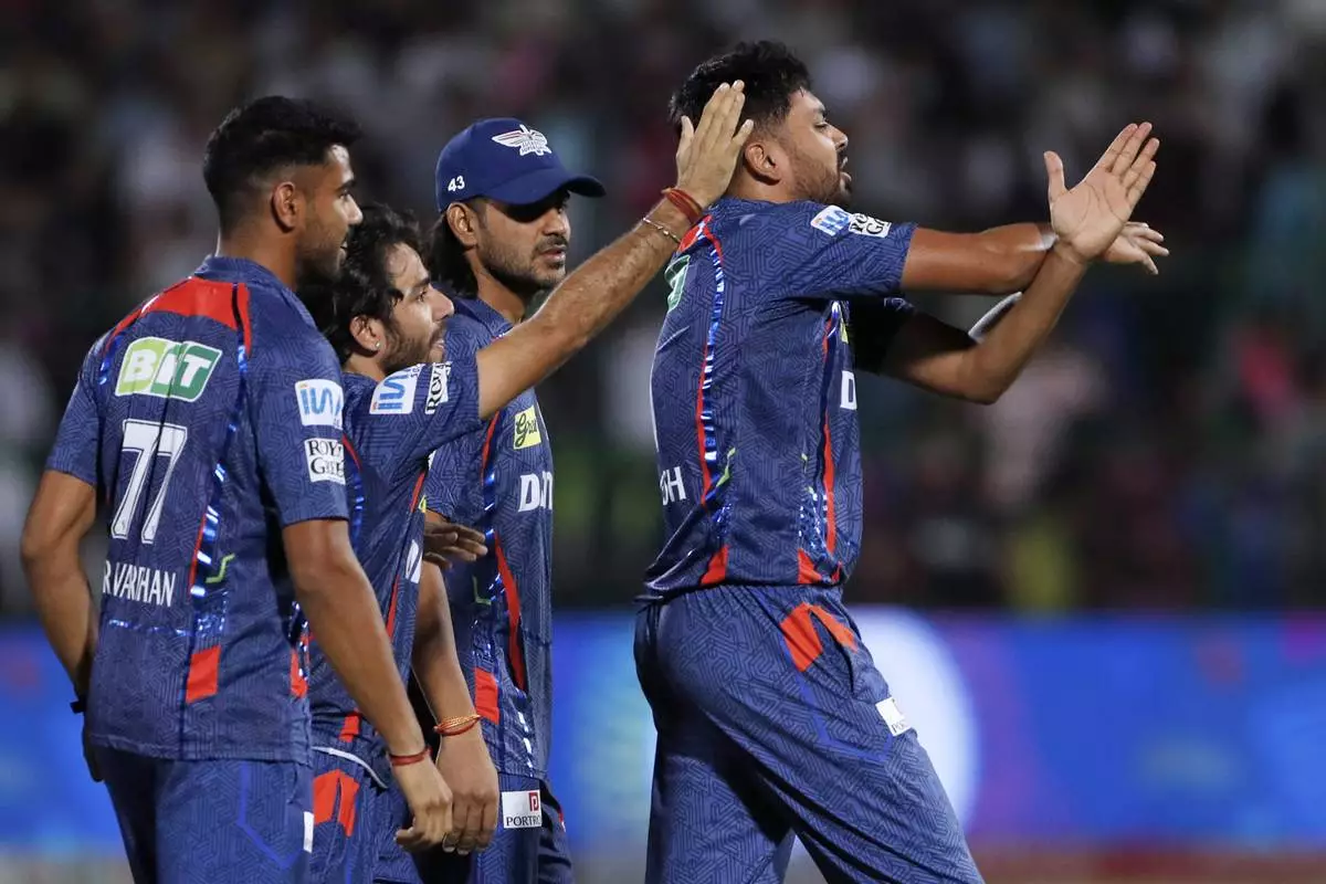 Lucknow Super Giants' Avesh Khan, right, calls for a physio after hurting his hand fielding on the last ball of the Indian Premier League cricket match between Lucknow Super Giants and Rajasthan Royals at Sawai Mansingh Stadium in Jaipur, India, Sunday, April 20, 2025. (AP Photo/Surjeet Yadav)