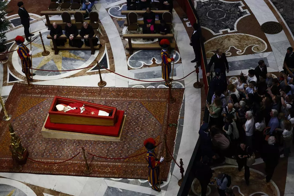 People queue to pay their respects to the late Pope Francis, who will lie in state at St. Peter's Basilica for three days, at the Vatican, Wednesday, April 23, 2025. (Cecilia Fabiano/LaPresse via AP)