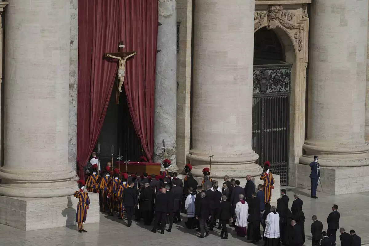 The body of Pope Francis is carried through St. Peter's Square to St. Peter's Basilica at the Vatican, Wednesday, April 23, 2025, where he will lie in state for three days. (AP Photo/Markus Schreiber)