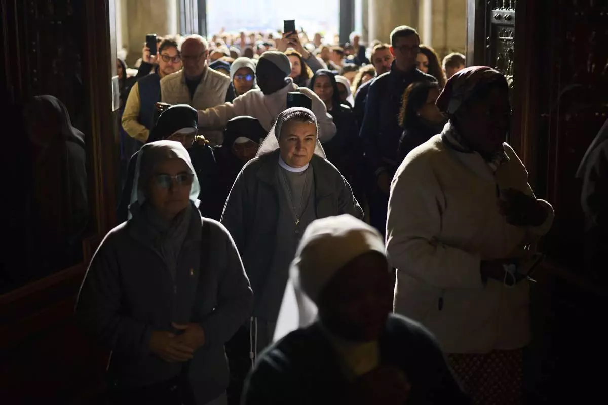 People line up as they enter St. Peter's Basilica to pay their respects to Pope Francis lying in state, at the Vatican, Thursday, April 24, 2025. (AP Photo/Emilio Morenatti)