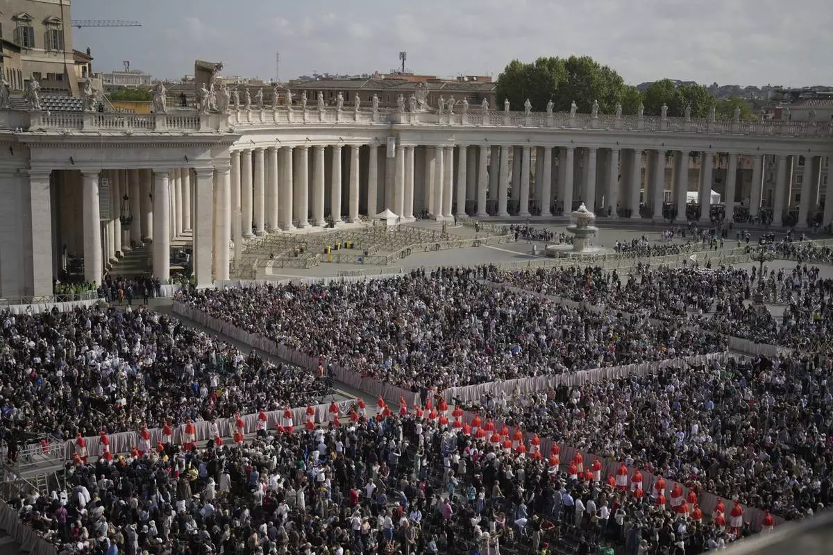People gather in St. Peter's Square as they await the arrival of the body of Pope Francis, who will lie in state at St. Peter's Basilica for three days, at the Vatican, Wednesday, April 23, 2025. (AP Photo/Markus Schreiber)