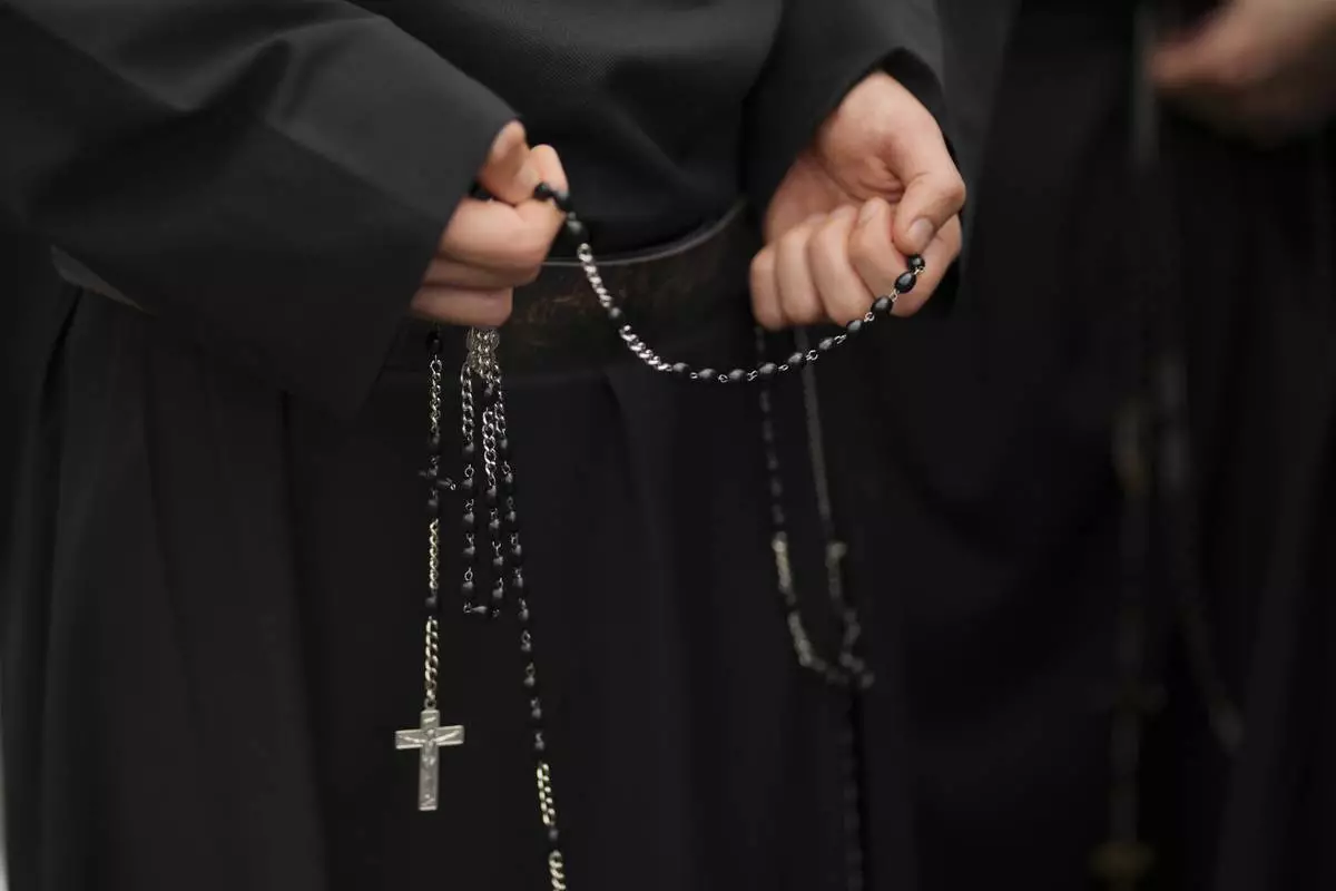 A faithful holds a rosary while waiting in line to enter St.Peter's Basilica to view Pope Francis lying in state, at the Vatican, Thursday, April 24, 2025. (AP Photo/Francisco Seco)